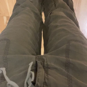 Gröna wide byxor från East West - Snygga gröna byxor från East West med bred passform och dragsko i midjan. Byxorna har raka ben, synliga sömmar och är tillverkade i linne material. Perfekta för en avslappnad och chill stil.