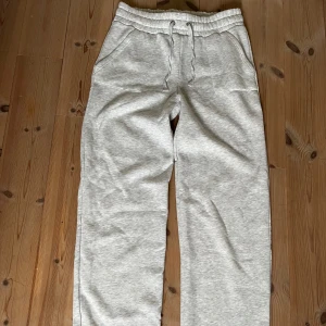 Lager 157 Grå mjukisbyxor  - Ljusgrå mjukisbyxor i storlek L med bred resår i midjan och snörning. Byxorna har raka ben och två sidofickor. Knappt använda