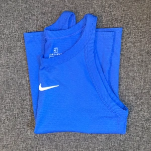 Nike träningslinne - Blått Nike träningslinne. Skön passform och jättefin färg💙Har en pytteliten defekt (bild 4) men inget jag märkt av! Säljer en likadan i rosa💕 Köp båda för 150kr🙌🏼