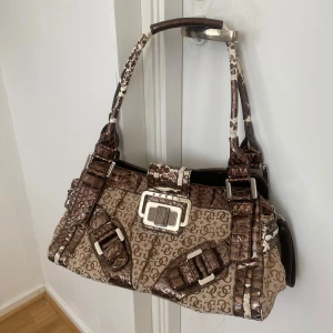 Handväska från Guess - Brun handväska från Guess😙Har använts mycket och har slitningar på utsidan men inget som förstör väskans normala funktion