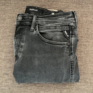 Svarta replay jeans - Snygga svarta Replay jeans med slitna detaljer och klassiska bakfickor med broderad design. Jeansen har normal passform och är tillverkade i mjukt denimtyg som gör den Ganska stretchig.