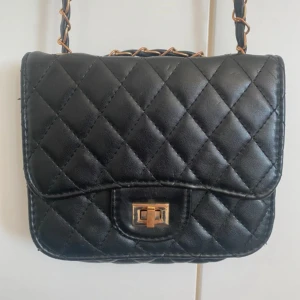 Svart axelväska med kedja - Snygg svart axelväska. 