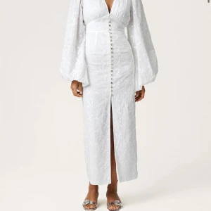 Adoore klänning vit - Superfin vit långklänning från Adoore, är uppsydd i ärmarna vilket gör att den ser mycket mer passande ut på kroppen när man bär den. Skriv för bilder