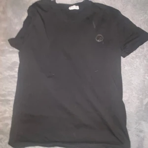 Svart Moncler t-shirt i bomull - Svart t-shirt från Moncler i mjuk bomull med klassisk passform. T-shirten har korta ärmar och en rund halsringning. På bröstet sitter en diskret Moncler-logga som ger en clean och stilren vibe.