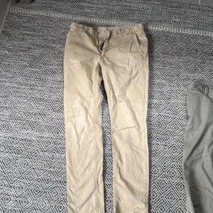 Beige chinos från Boomerang W31 L34 - Snygga beige chinos från Boomerang i klassisk rak modell. Byxorna har fickor fram och bak, bälteshällor och är tillverkade i bomull. Perfekta för en clean och avslappnad stil.