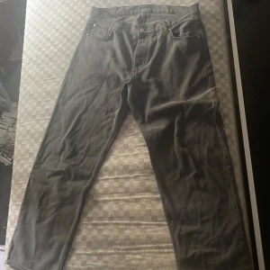 Svarta raka jeans - Säljer ett par svarta jeans med klassisk femficksdesign och raka ben. Jeansen har normal passform och är tillverkade i ett robust jeanstyg. Perfekta för dig som gillar en enkel och stilren look.