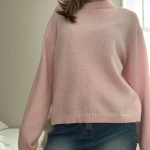 Ljusrosa stickad tröja - Supermjuk och mysig ljusrosa stickad tröja med avslappnad passform. Tröjan har rund halsringning, långa ärmar och ribbade muddar vid ärmslut och nederkant. Perfekt för lager-på-lager och chill dagar.