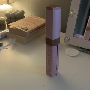 Rosa plattång - Säljer en snygg portabel plattång i ljusrosa med bruna detaljer. Den har ett mönstrat grepp, USB-C laddning och smidig storlek som passar perfekt i väskan. Perfekt för att fixa håret snabbt när du är på språng. Säljer då jag råkade köpa 2st. Köp direkt för 300kr. Kvitto finns online. 