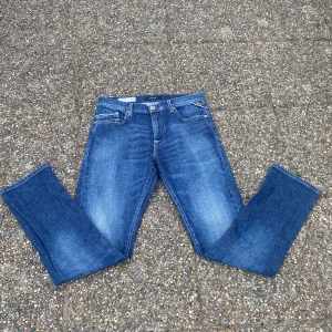 Blå Replay Mini Waitom jeans - Snygga blå jeans från Replay, modell Mini Waitom. Klassisk femficksdesign med raka ben och normal passform. Jeansen har tydliga Replay-detaljer som logga på fickan och läderpatch bak. Tillverkade i slitstarkt denim med snygg tvättad look. Priset är inte hugget i sten!