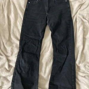 Svarta jeans från Gina Tricot, strl 34 - Svarta jeans från Gina Tricot i modellen Perfect Jeans. Klassisk femficksdesign, raka ben och normal passform. Jeansen är tillverkade i bomull med en snygg mörk tvätt och diskreta sömmar. Perfekta till sneakers eller boots.