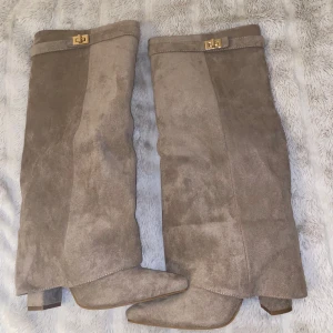 Beige mockastövlar med gulddetalj - (Kan gå ned i pris vid snabb affär!) Snygga höga stövlar i beige mocka med spetsig tå och hög klack. Nya därav aldrig använt! Perfekta nu för höst och vinter 🍁❄️ 