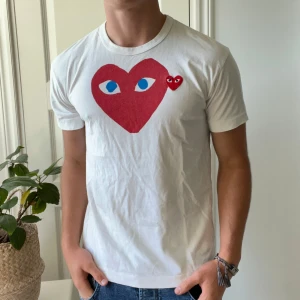 Vit Comme des Garçons Play t-shirt - Inga defekter, vit CDG t shirt. Säljs för lite dyrare då jag verkligen gillar tröjan😅. Storlek L men passar m. Modellen är 180,75 kg. Kom med frågor! 