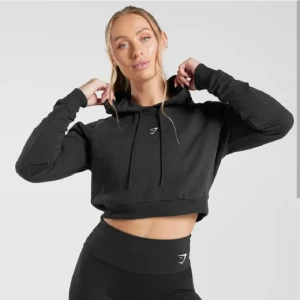 Svart croppad hoodie från Gymshark - Snygg svart croppad hoodie från Gymshark i stlk XS (passar mig som brukar vara S), som ny. Nypris 699 och slutsåld. Kan skicka egna bilder vid behov, väldigt mjukt skönt tunnare material. Säljer även en i röd. Båda för 200kr
