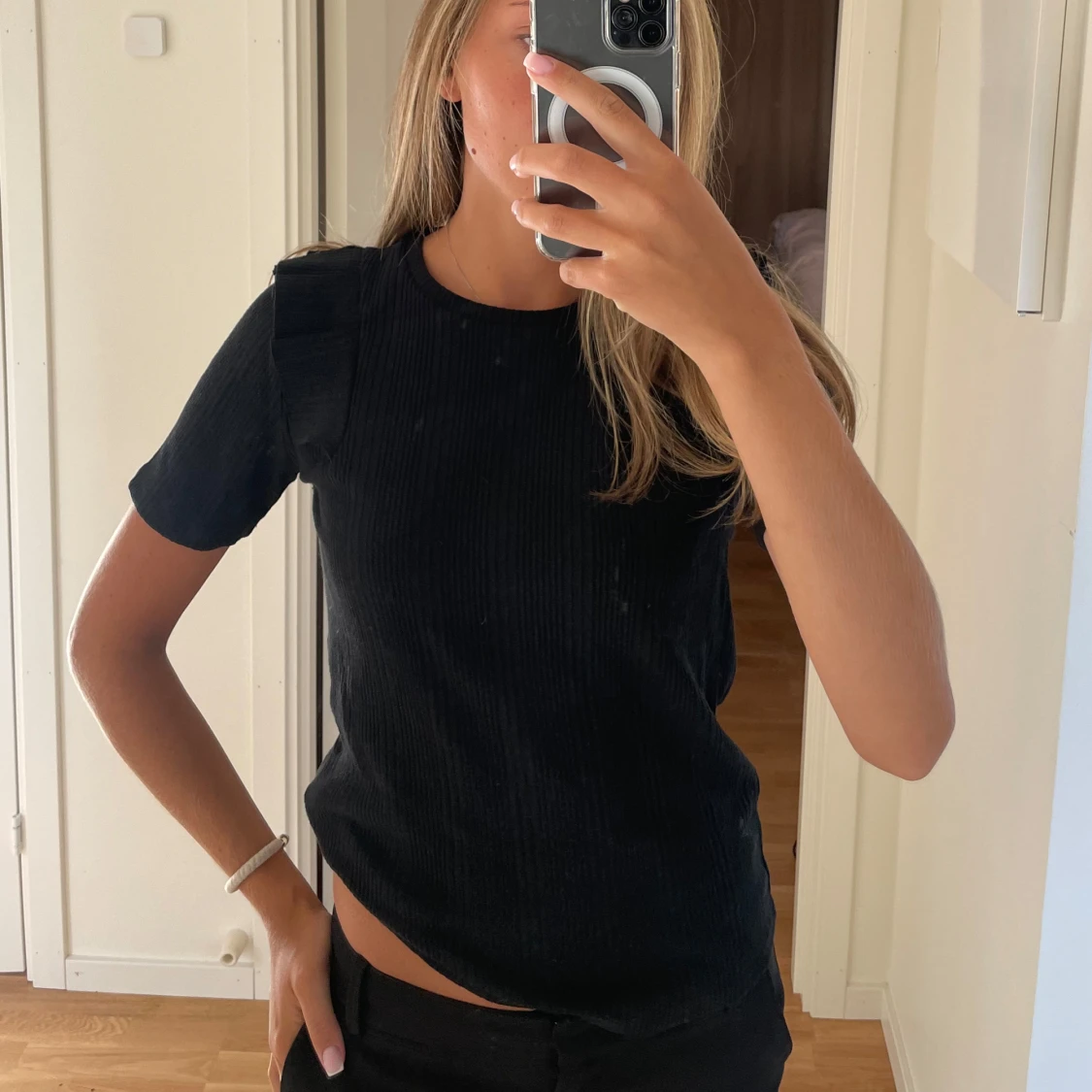 Svart T-shirt med volanger.