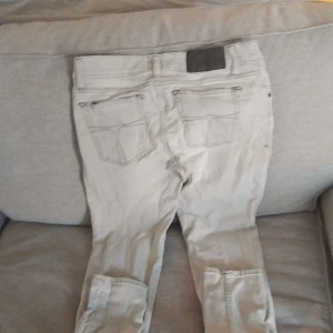 Beiga jeans från Tiger of Sweden - Snygga beiga jeans från Tiger of Sweden med klassisk femficksdesign och diskreta sömmar. Jeansen har raka ben och normal passform, perfekta för en clean och stilren look.Lite stretch Tillverkade i mjuk bomull för skön känsla hela dagen.