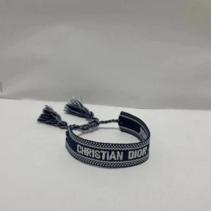 Blått armband - Supersnyggt blått armband med vit text '. Armbandet har flätade band och två tofsar som ger en cool och trendig vibe. Perfekt accessoar för att lyfta din outfit. Helt nytt bara för 225kr. Priset kan alltid diskuteras! 