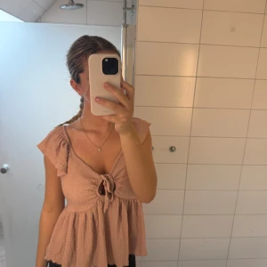Rosa blus - Supersöt rosa blus med volang i ärmarna och knytning framtill. Köpt från lager 157 och är i storlek M