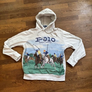 Vit hoodie Polo Ralph Lauren M - Vit hoodie från Polo Ralph Lauren med stor tryck på. Bra skicket och säljer denna då den börjat bli för kort. Storleken är medium men passar även small. Köpte hoodien på en outlet i Spanien för 2000 kr, säljer nu otroligt billigt. Bara att skriva vid minsta funderingen!😊