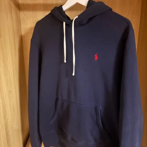 Marinblå hoodie från Polo Ralph Lauren - Snygg marinblå hoodie från Polo Ralph Lauren. Som är endast använd fåtal gånger. Priset är absolut diskuterbart.