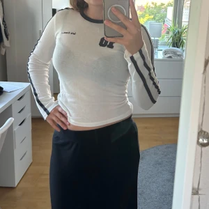 Långärmad tröja  - Säljer en cool vit långärmad tröja med svartgrå ränder längs ärmarna och trycket '10' på ryggen! Den är knappt använd och därför säljer jag den. Storlek M men den funkar nog på S om man vill ha den mindre tajt! Skriv om du har frågor eller undrar något!💖