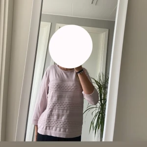 Ljusrosa tröja från Micha med struktur  - Supersöt ljusrosa tröja från Micha i storlek M. Tröjan har trekvartsärm och snygga strukturerade ränder framtill som ger en unik look. Mjuk och skön, perfekt till både jeans och kjol. Rund halsringning och avslappnad passform.