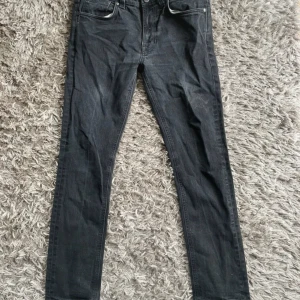 Svarta/grå jeans från Nudie Jeans - Säljer ett par svarta/ grå nudie jeans i modellen Lean Dean. Strlk W33, L32. Mycket bra skick