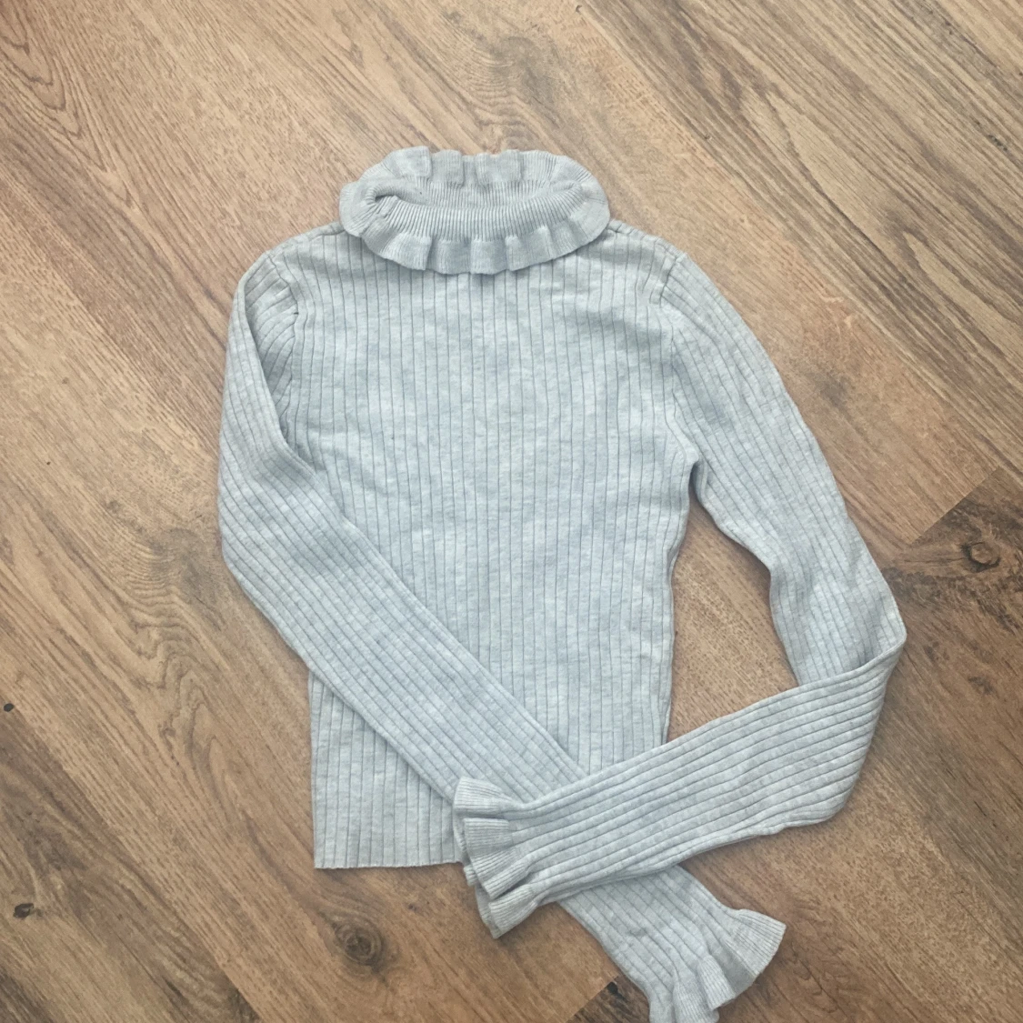 Ljusgrå ribbad polotröja med volang