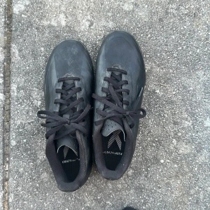 Svarta Adidas fotbollsskor crazyfast använda 1-2 veckor växt ut dom perfekt till skolan på raster t.ex - Säljer ett par svarta Adidas fotbollsskor med snörning och rund tå. Skorna har en mönstrad sula med dobbar som ger bra grepp på konstgräs. Ovandelen är i syntetmaterial och designen är stilren och sportig. Perfekt för dig som vill ha en clean look på planen.