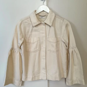 Norr HannaLi Ecru Vit denimjacka, storlek 34 - Jättefin tunn och luftig jacka perfekt till våren eller hösten. Jackan har två fickor på bröstet och vida ärmar. Endast använd en gång, så jackan är i nyskick! Nypris 1500:-.  Fler bilder och info finns på länken från Zalando nedan:  https://www.zalando.se/norr-skjorta-ecru-noe21g00y-b11.html