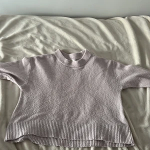 Ljusrosa stickad tröja Gina Tricot - Säljer en ljusrosa stickad tröja från Gina Tricot med rund hals och ribbade muddar vid hals, ärmslut och nederkant. Tröjan har lång ärm och är perfekt för dig som gillar mjuka och mysiga plagg med enkel design. Passar dig som vill ha en chill och stilren look.