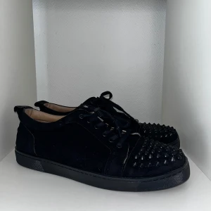 Christian Louboutin  - Säljer ett par svarta Christian Louboutin med mockaliknande material och svarta nitar på tån. Skick 8/10, Storlek 44, osäker på äkta därav priset. Pris går att diskutera✅