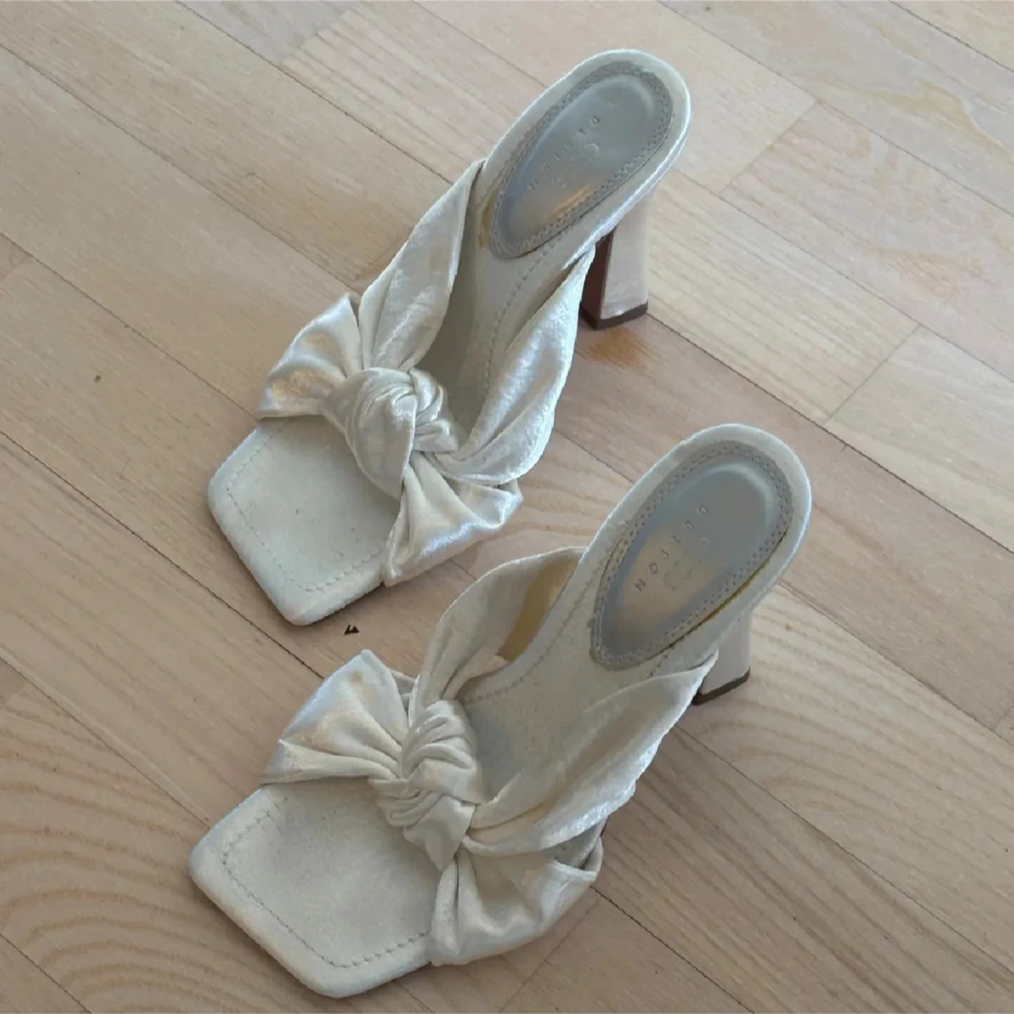 Vita klackskor med rosettdetalj