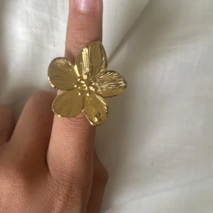 Stor guldig blomring - Jag säljer en populär guldig blom ring, denna är köpt från raglady och är värt ungefär 300-400 kr, jag säljer den pga att den är i fel färg och jag föredrar silver istället. Den är dock lite böjd där man sätter i fingret men funkar fortfarande bra! 💞💞