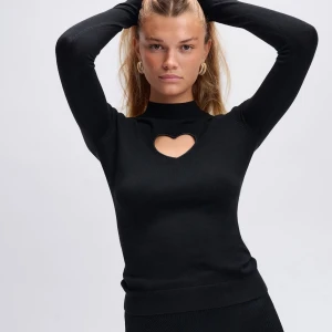 Svart tröja med hjärtformad cut-out Cloeys - Svart långärmad tröja från Cloeys med en snygg hjärtformad cut-out vid halsen. Tröjan har ribbad krage och är helt oanvänd.