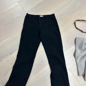 Svarta kostymbyxor från Nelly - Säljer ett par stilrena svarta kostymbyxor från Nelly i storlek 36. De har en klassisk design med rak passform och låg midja. 
