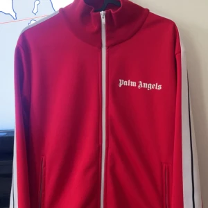 Röd Palm Angels track jacket M - Palm Angels track jacket i rött, 100% autentisk ifrån farfetch. Hel dragkedja framtill och logga på bröstet. Perfekt för dig som gillar hype beast stilen! Köpt för 3995kr (obs! priset är ej hugget i sten)