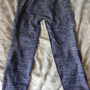 Blåmelerade träningstights - Snygga blåmelerade träningstights med tight passform och stretchigt material. Perfekta för gymmet eller löprundan, med coola stickade detaljer längs benen för extra stilpoäng.