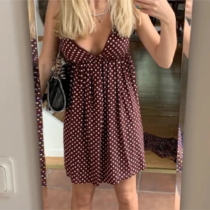 Klänning  - Säljer en söt röd kortklänning med vita prickar och djup v-ringning. Jättefin nu till sommaren