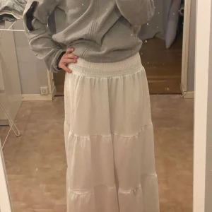 Vit långkjol med resårmidja - Säljer en vit långkjol med lite  volangdetaljer. Kjolen är luftig, perfekt för varmare dagar. denna är aldrig använd! 