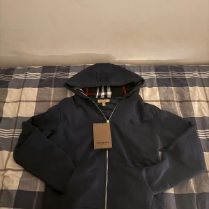 Burberry zip hoodie - Säljer en mörkblå hoodie från Burberry med dragkedja. Pris är inte helt bestämt och kan diskuteras vid snabb affär!