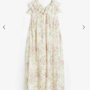 HM Blommig långklänning med volang - Söt långklänning från HM med blommigt mönster i ljusa toner. Klänningen är sparsamt använd och  har smala justerbara axelband och en volangdetalj vid bysten. Perfekt för varma dagar och somriga tillfällen.🌸