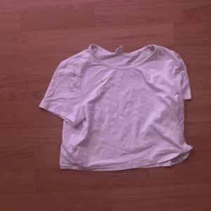 Vit croppad t-shirt från SHEIN - En enkel vit croppad t-shirt från SHEIN. T-shirten har korta ärmar och rund halsringning. Perfekt för en avslappnad stil och lätt att matcha med andra plagg.
