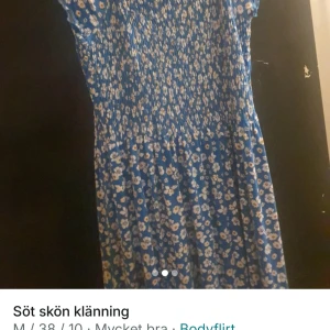 Blommig blå klänning från Bodyflirt - Supersöt blå klänning med vitt blommönster från Bodyflirt. Klänningen har korta ärmar och smock upptill för en bekväm passform. Perfekt för varma dagar och ger en fräsch look.