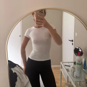 Vit tight t-shirt - Säljer en klassisk vit t-shirt med tight passform och korta ärmar. Perfekt basplagg som funkar till det mesta. Enkel och stilren design utan synliga loggor eller mönster.