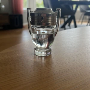 Paco Rabanne Invictus parfym - Säljer en ikonisk Paco Rabanne Invictus parfym i en cool troféformad flaska. Flaskan är genomskinlig med silverfärgade detaljer och handtag på sidorna. Perfekt för dig som gillar fräscha och sportiga dofter. Ungefär 70 procent kvar i flaskan men lika högkvalitativ 