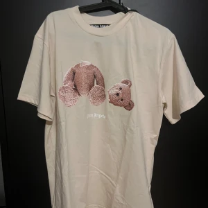 Beige Palm Angels t-shirt med björntryck - Säljer min Palm angels tshirt då den inte används, storlek S men passar även M. Helt nytt skick!