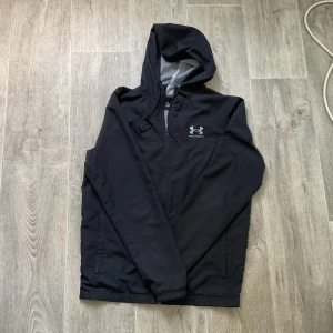Svart Windbreaker från Under Armour - Under Armour vindjacka Snygg och sportig svart jacka från Under Armour i storlek S (loose fit) – perfekt för vår sommar och höst!  🖤 Tunn och lätt med ventilerande mesh-foder 💨 Skyddar mot vind och lätt regn 🧥 Sitter bekvämt med avslappnad passform ✔️ Fint Skick  Perfekt för dig som gillar sportig streetwear eller behöver en praktisk jacka till vardags.  Möts upp eller skickas – du väljer! Skicka PM vid frågor 💬 
