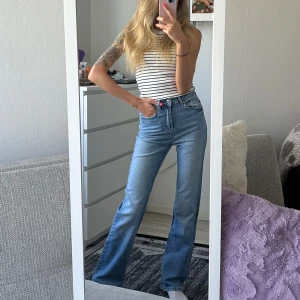 Blå jeansbyxor från Stradivarius - Säljer ett par klassiska blå jeans från Stradivarius med raka ben och normal passform. Jeansen har fem fickor, knappgylf och bälteshällor. Perfekta till vardags och lätta att matcha med olika stilar.