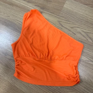 Orange topp - En orange topp i stl M som aldrig är använd säljs för 60 kr. 