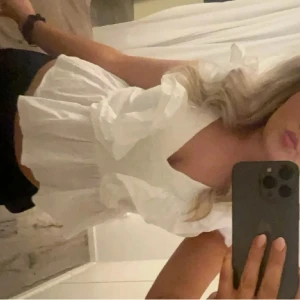 Vit volangblus från H&M - Supersöt vit blus från H&M med volanger längs axlar och framtill. Blusen är ärmlös och har en lätt croppad passform med v-ringning. Perfekt för dig som gillar romantiska detaljer och en luftig känsla. Tillverkad i bomull och linne för en fräsch look. Storlek 38 men passar s